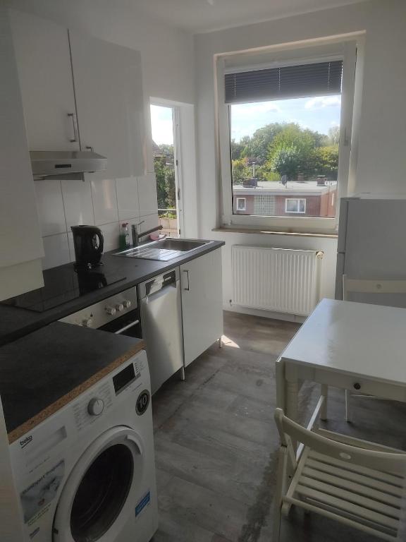 een keuken met een wasmachine en een wastafel bij Ganze Wohnung mit privatem Balkon in Gelsenkirchen