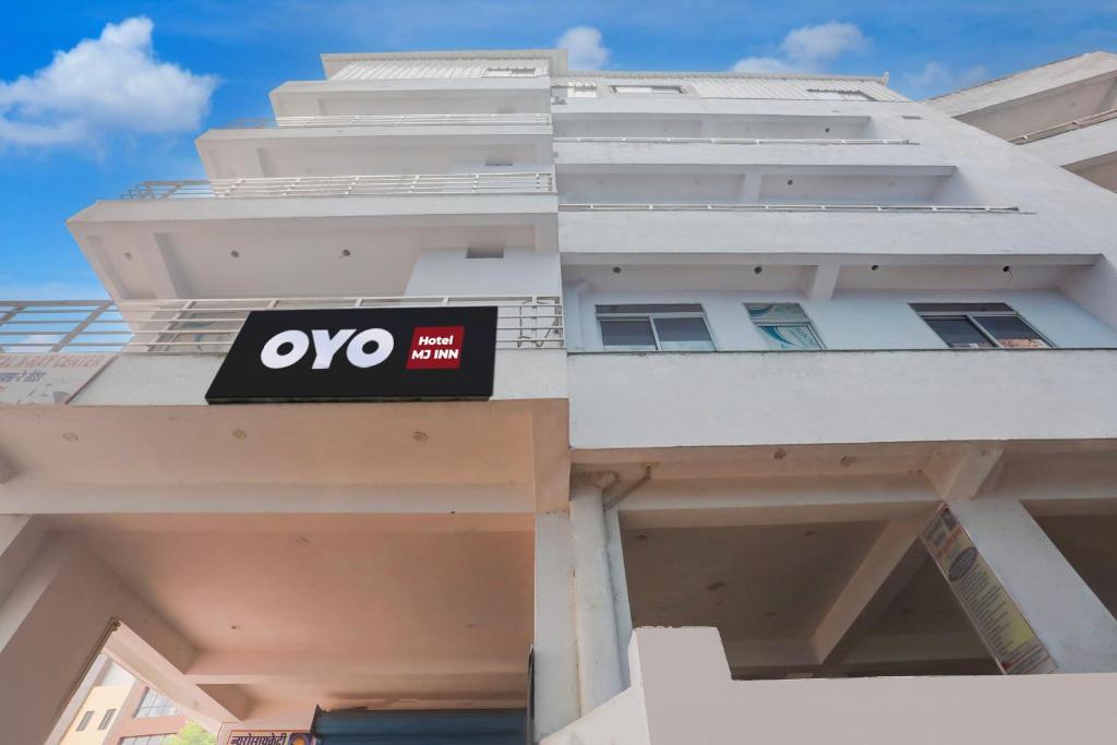 DarbhangaHOTEL O MJ INN的白色建筑的侧面标志