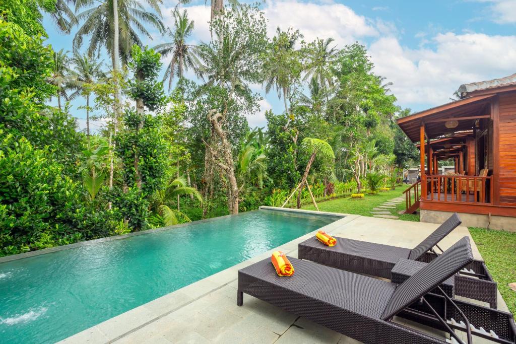 an image of a swimming pool in front of a house at Pondok Naples Ubud in Ubud