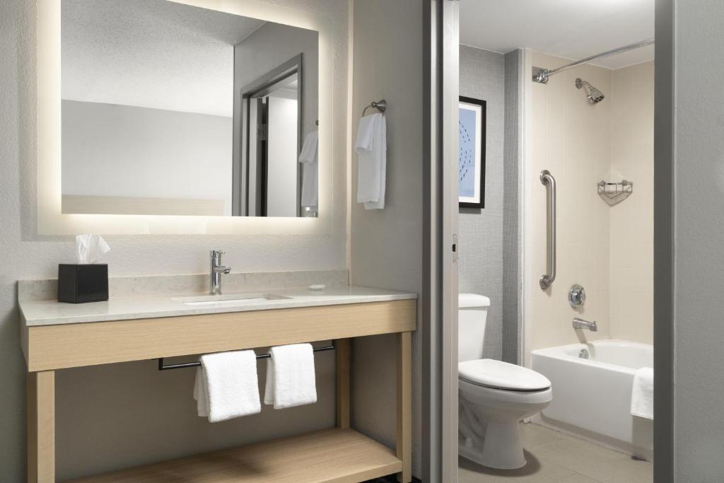 ein Badezimmer mit Waschbecken, Toilette und Spiegel in der Unterkunft Hyatt Select Richmond Chester in Woodvale