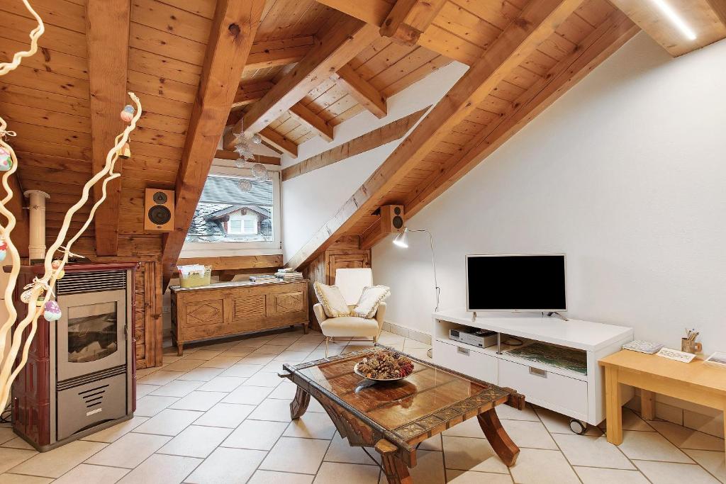 a living room with a table and a tv at Il Nido Aosta in Aosta