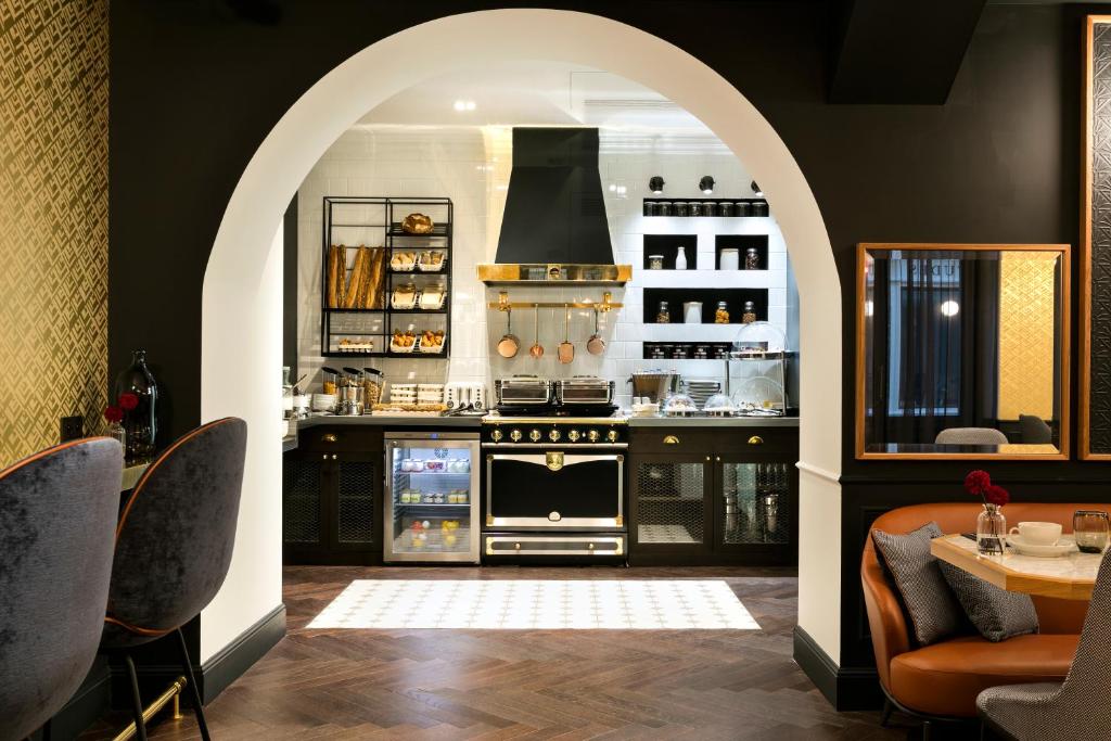 an archway in a kitchen with a stove and a table at Hôtel Square Louvois in Paris