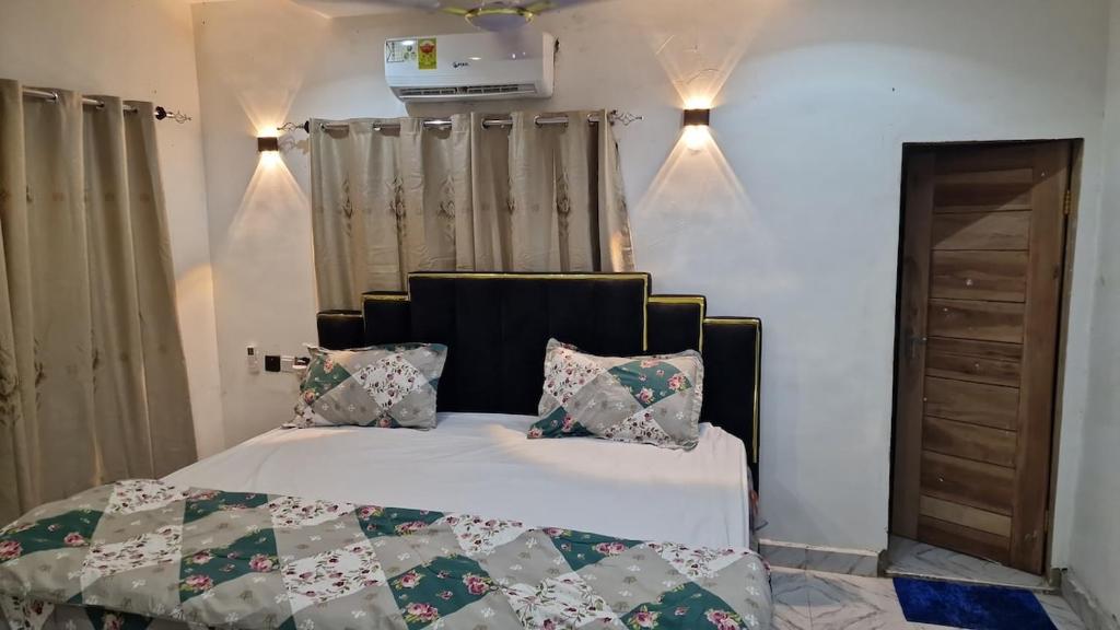 - une chambre avec un lit doté d'une tête de lit et d'oreillers noirs dans l'établissement Luxury Hideout, 