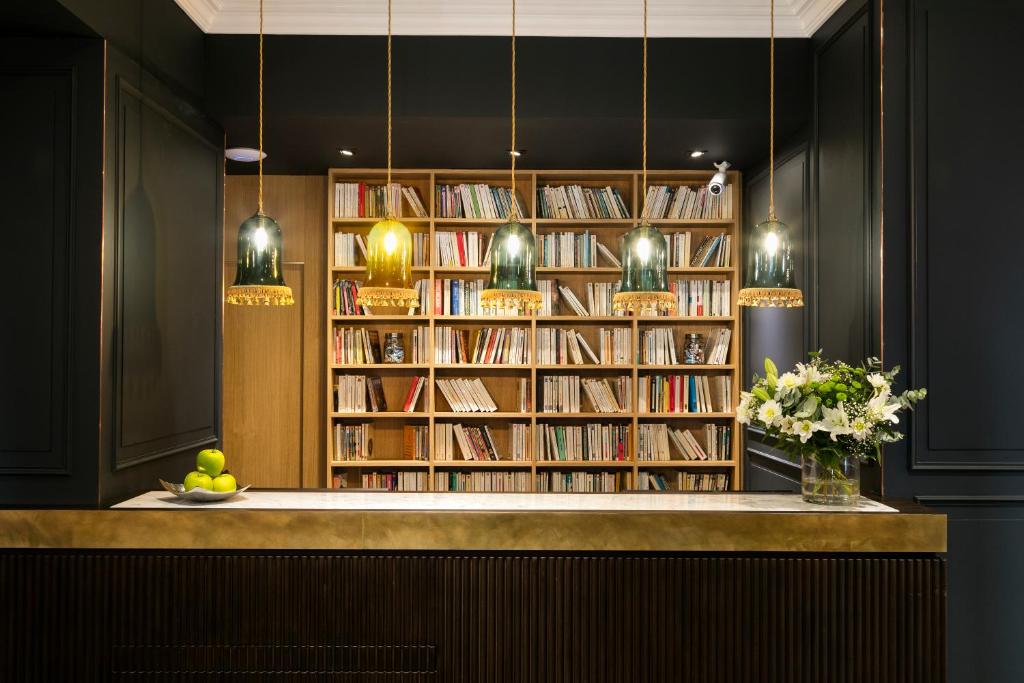 a library with book shelves filled with books at Hôtel Square Louvois in Paris