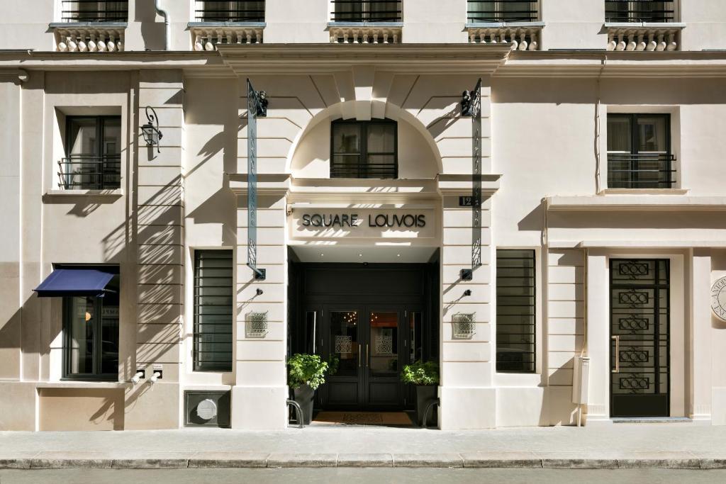 a white building with the entrance to some lounges at Hôtel Square Louvois in Paris