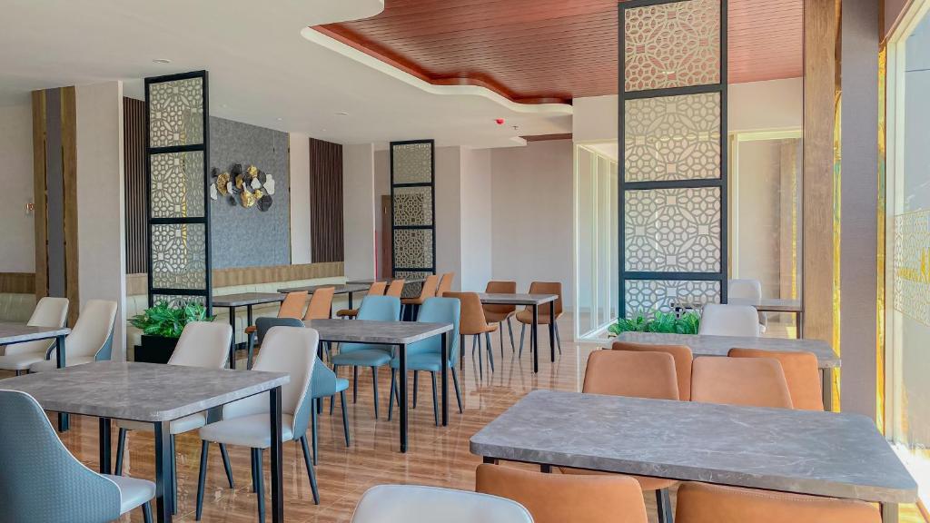 een eetkamer met tafels en stoelen in een restaurant bij Azana Style Hotel Jombang in Peterongan