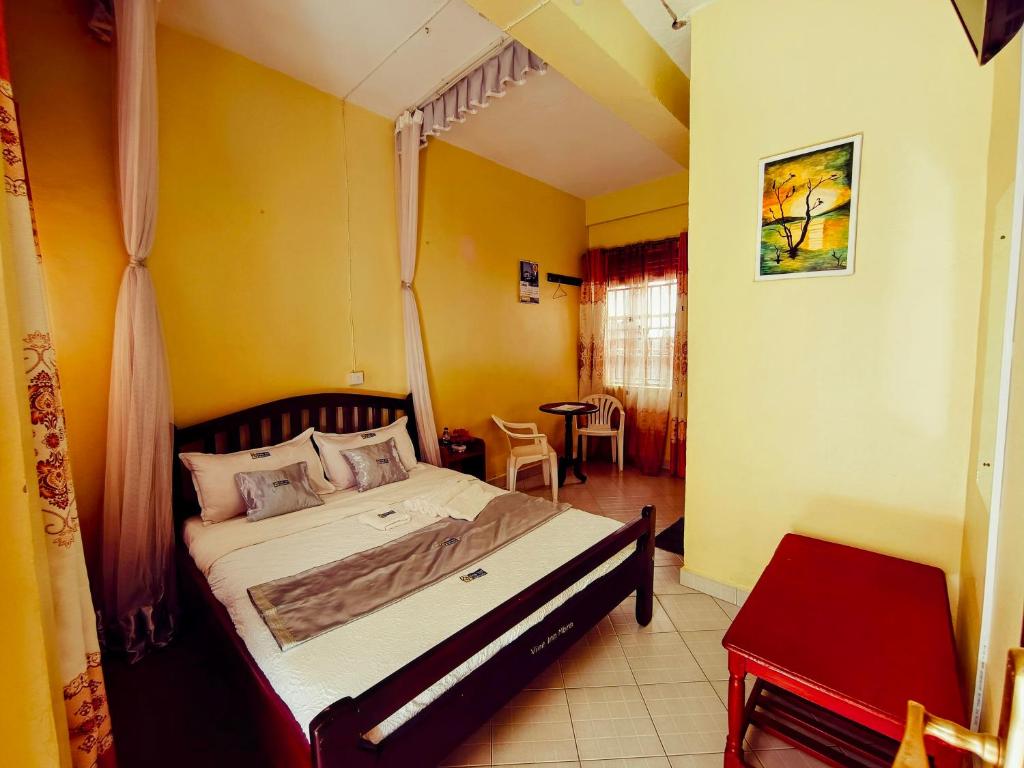 une chambre avec un grand lit dans une pièce dans l'établissement Vine Inn Mbarara, à Mbarara