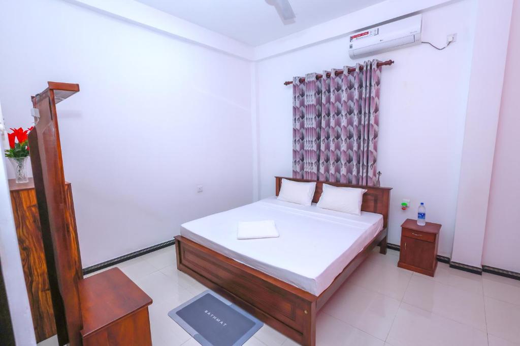 een kleine slaapkamer met een bed en een raam bij Grand Seraya - Negombo in Negombo