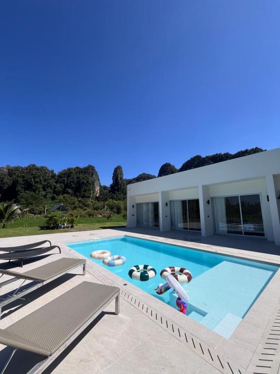 een groot zwembad met twee personen in een huis bij วันทน่า พูลวิลล่า เนินมะปราง in Ban Mung