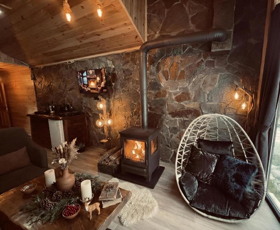 a living room with a fireplace and a couch and a stove at Ayder Luxury Resort - Riverside Villas & Bungalows in Çamlıhemşin