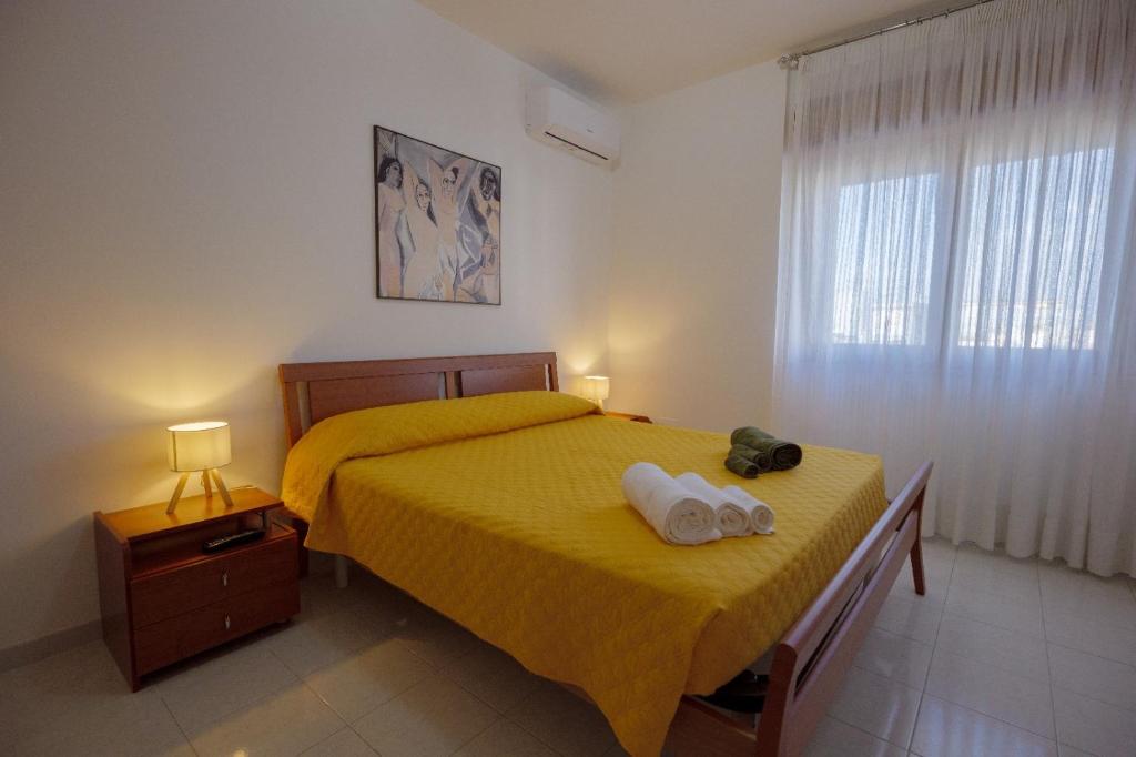 a bedroom with a yellow bed with two towels on it at Tree home in Salerno Airport - Aeroporto di Salerno