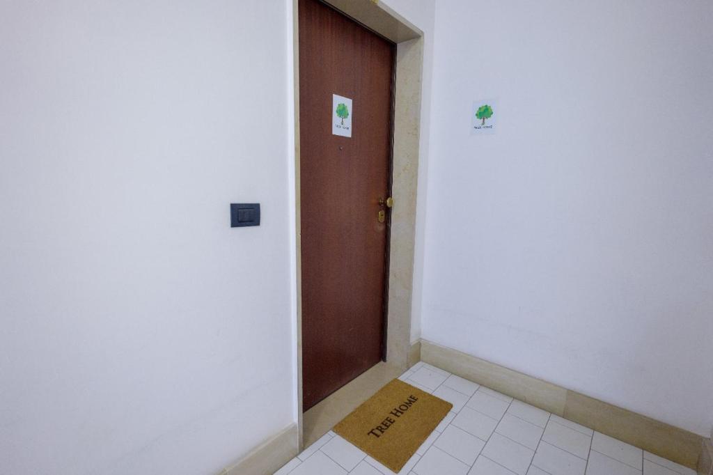 Salerno Airport - Aeroporto di SalernoTree home的走廊里，一扇门，门边地板上放着一个纸箱。