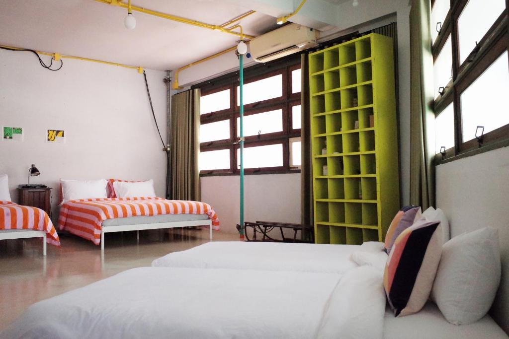 een kamer met 2 bedden, 2 stoelen en ramen bij The Urbanists BKK Entire Floor 4-6 people 4Beds 4Baths near Medpark Hospital , Queen Sirikit Convention hall , Benjakitti Park in Bangkok