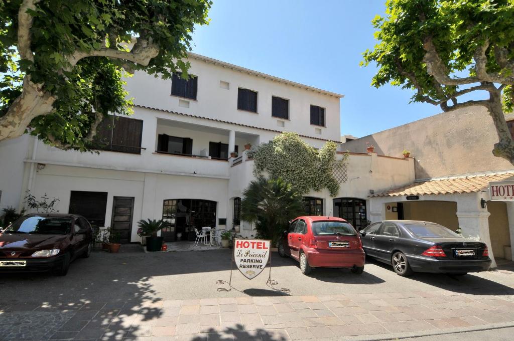 a parking lot with cars parked in front of a building at Le Preconil in Sainte-Maxime