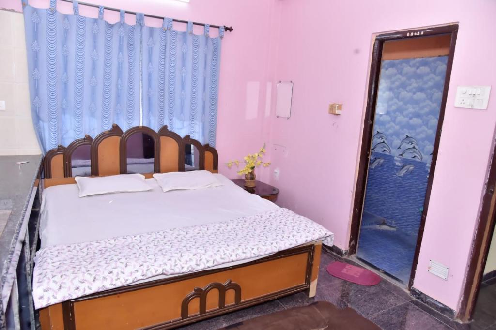 una camera da letto con un letto, una tenda blu e una porta di Samarth Villa a Akalkot