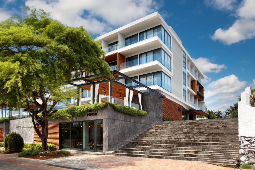 an apartment building with stairs and a tree at Hotel Indigo - Galapagos by IHG in Puerto Baquerizo Moreno