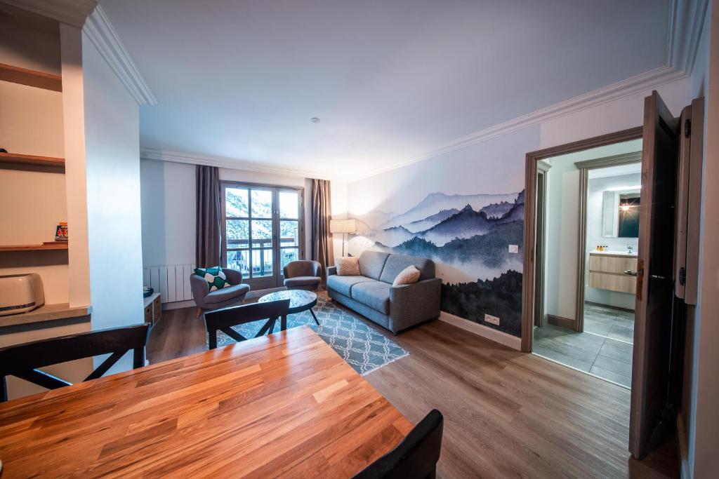 een woonkamer met een bank en een tafel bij Le Refuge d'Elyze in Arc 1950