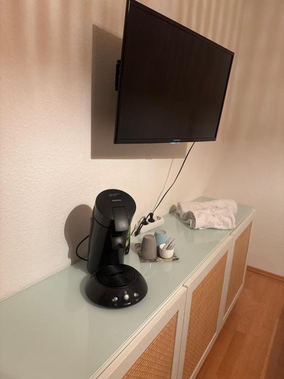 a table with a black coffee maker and a tv at Übernachten in Stuttgart