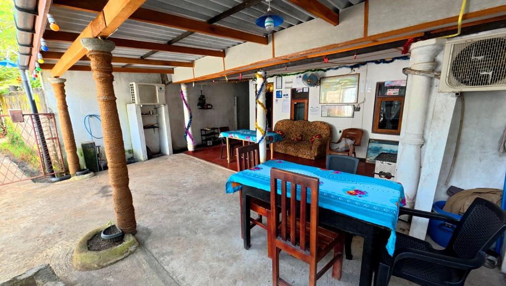 een patio met een blauwe tafel en stoelen in een huis bij Little House Inn Anuradhapura in Anuradhapura