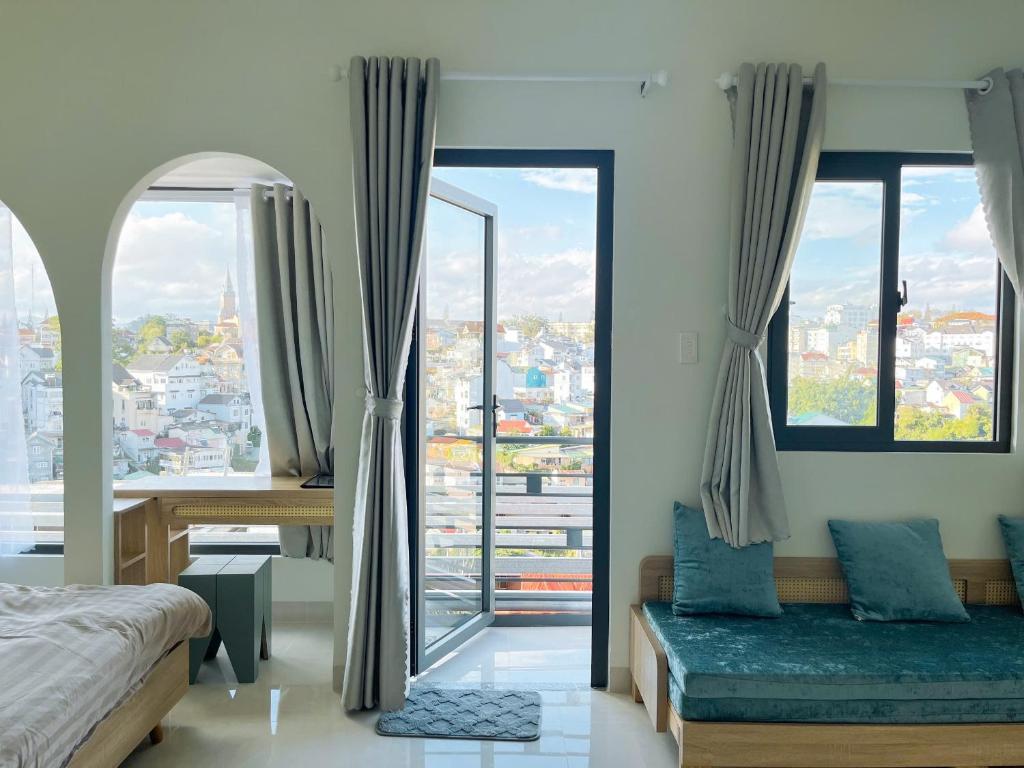 une chambre avec deux lits et une grande fenêtre dans l'établissement LENA Home, à Đà Lạt