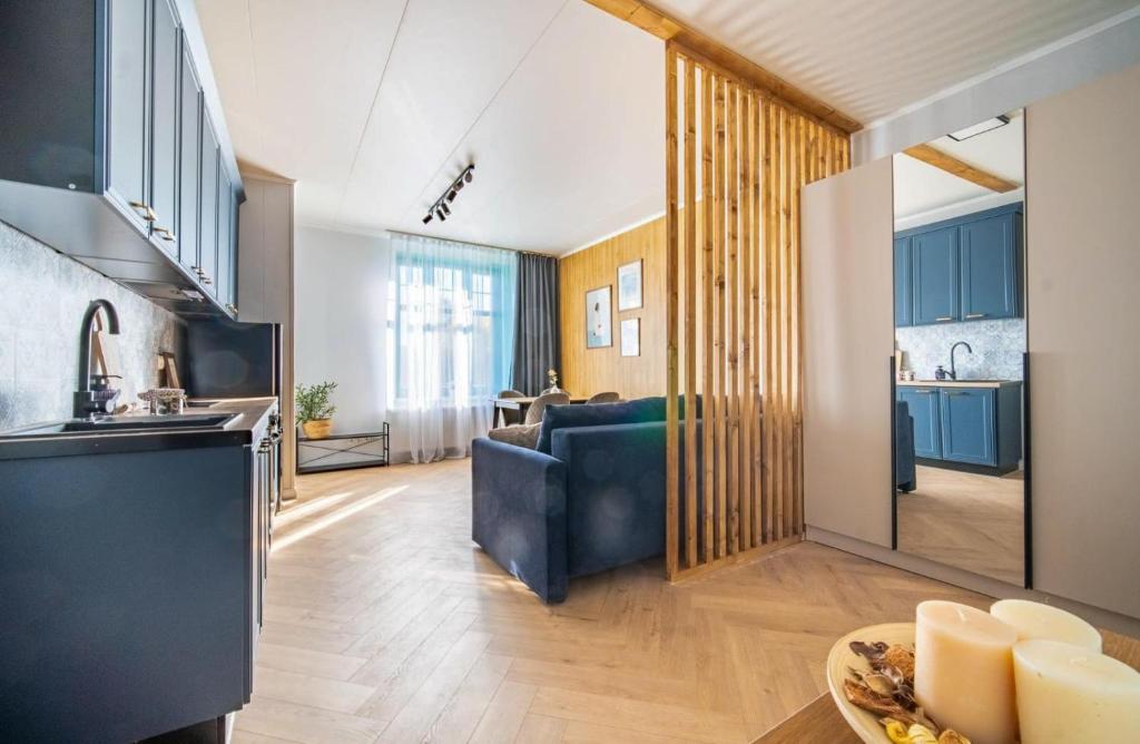 a kitchen and living room with blue cabinets and a couch at Willa na Dębowej in Katowice