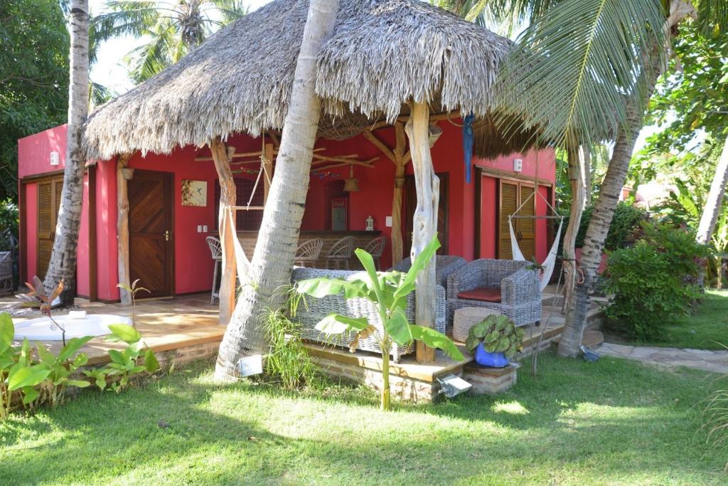una pequeña casa roja con techo de paja en Pousada Rio Verde Ltda, en Icaraí