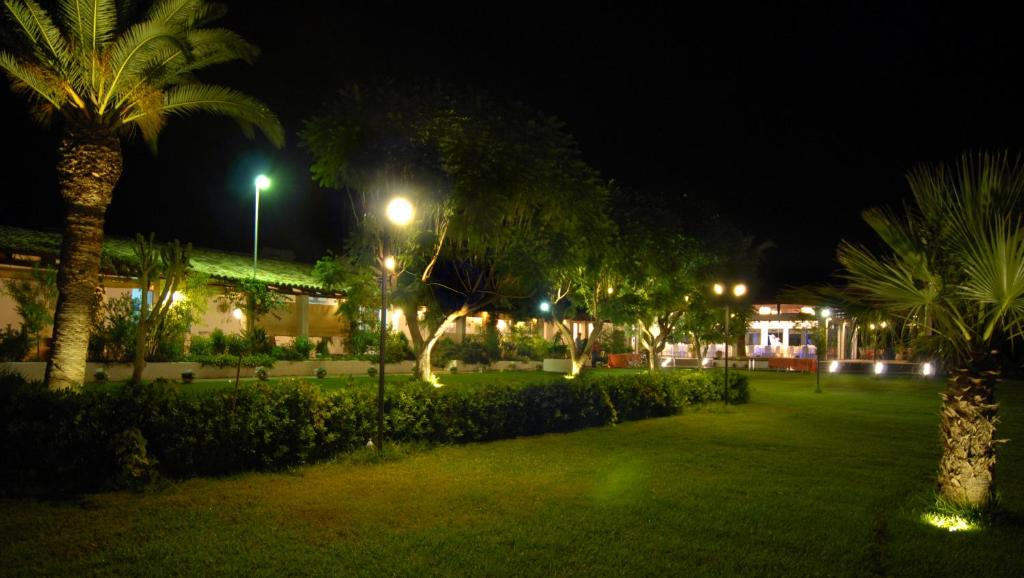 a park at night with palm trees and lights at Il Vigneto Resort in Menfi