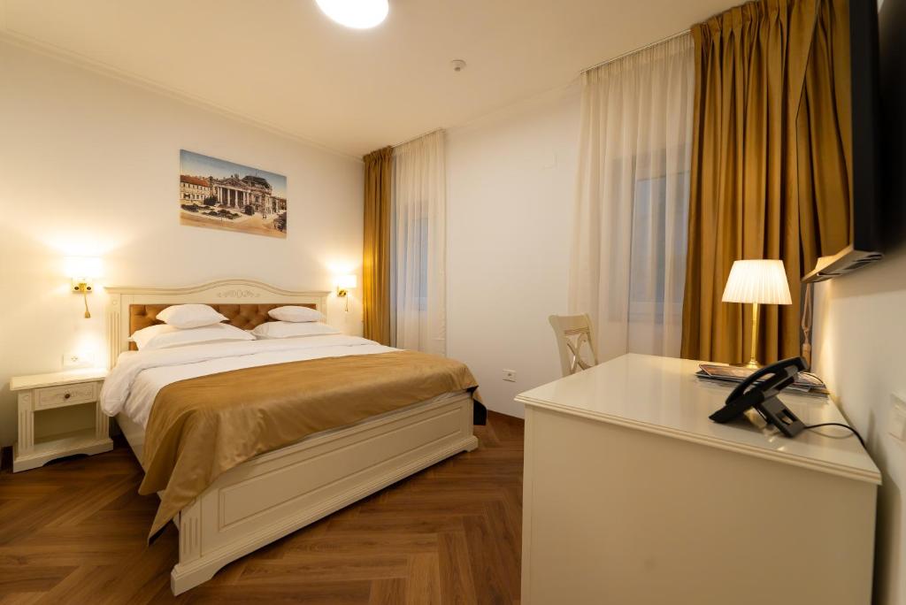 ein Hotelzimmer mit Bett und Schreibtisch in der Unterkunft Casa Doseanu in Oradea