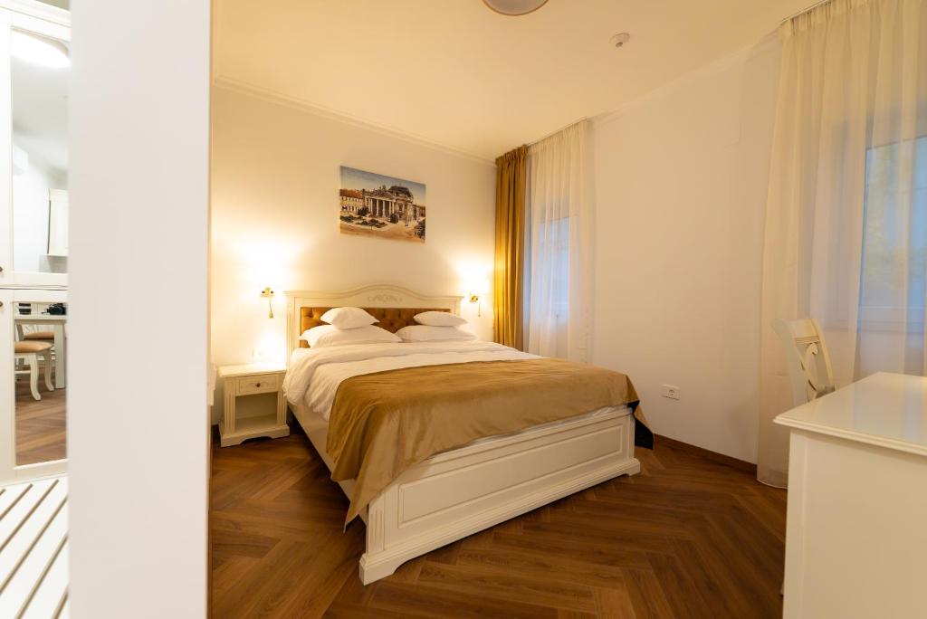 een slaapkamer met een bed, een bureau en een raam bij Casa Doseanu in Oradea