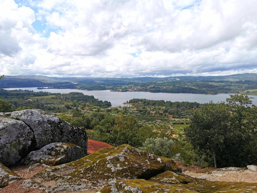 a view of a lake from a mountain with rocks at Casa Castro - Refúgio Rural em Fonte Arcada, Silêncio e Conforto in Fonte Arcada