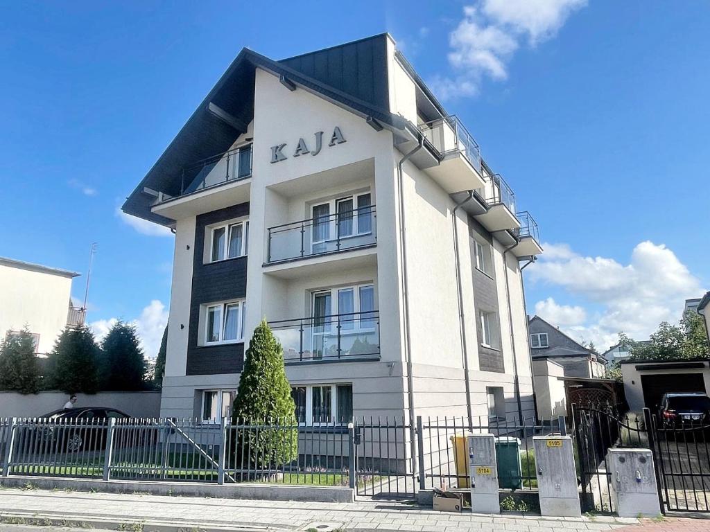 een groot wit gebouw met de letters Alaza erop bij pensjonat KAJA 200 metrów od morza in Międzyzdroje