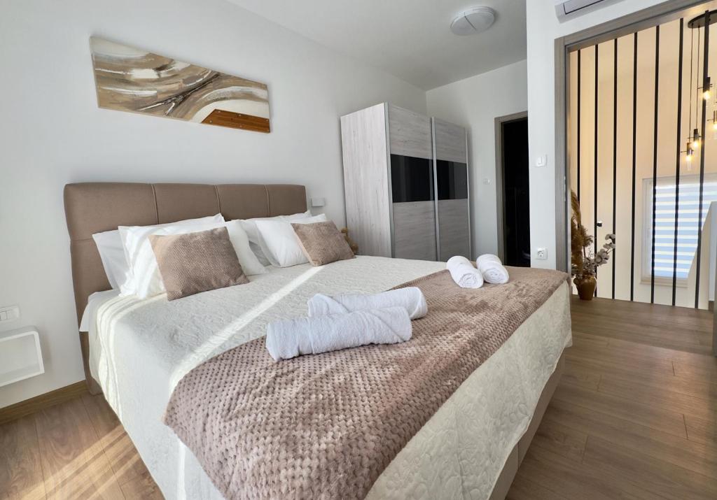 een slaapkamer met een groot bed met handdoeken erop bij Vila Gaspar in Dražice