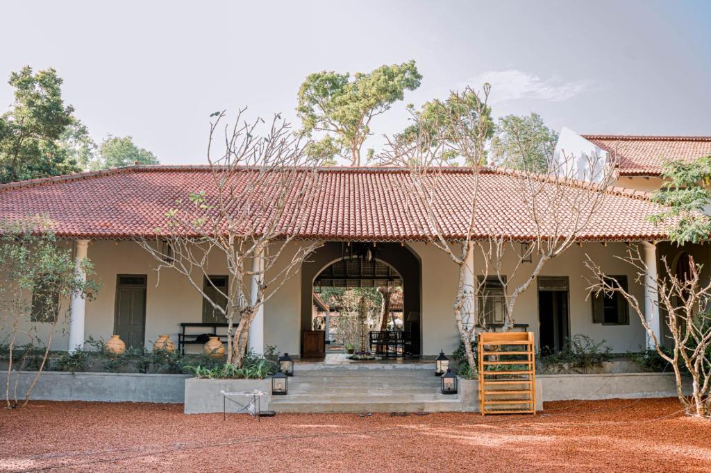 een huis met een rood dak en een veranda bij Rekawa Wellness Resort in Tangalle