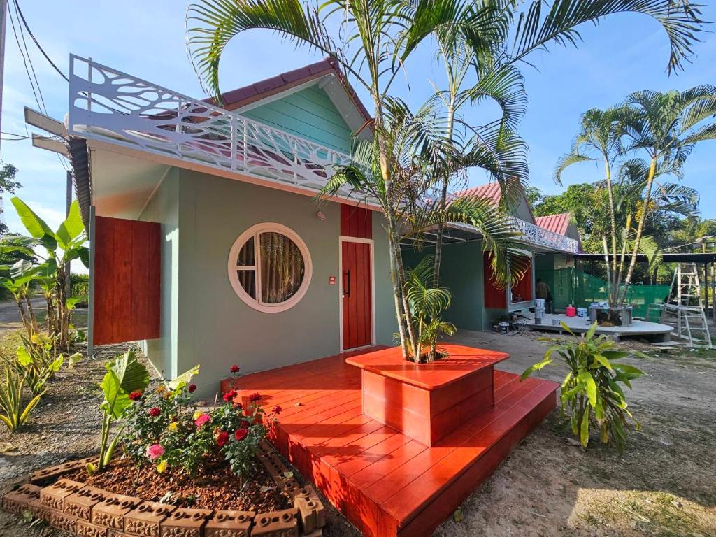 een huis met een houten terras ervoor bij คุณเก้า รีสอร์ท in Non Sa-at