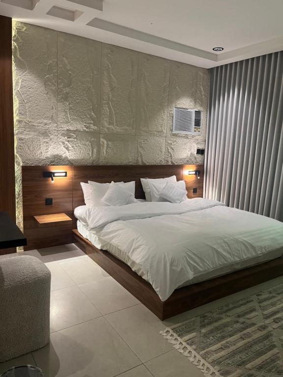een slaapkamer met een groot bed met witte lakens bij نزل Rest in Hail