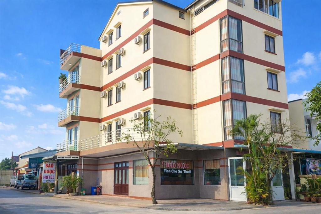 ein hohes Gebäude auf einer Straße mit Bäumen davor in der Unterkunft Bảo Ngọc Hotel Đông Hà in Quang Tri