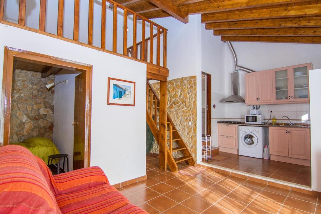 una cocina y una sala de estar con una escalera en una casa en Akivillas Lagos Quiet en Barão de São Miguel