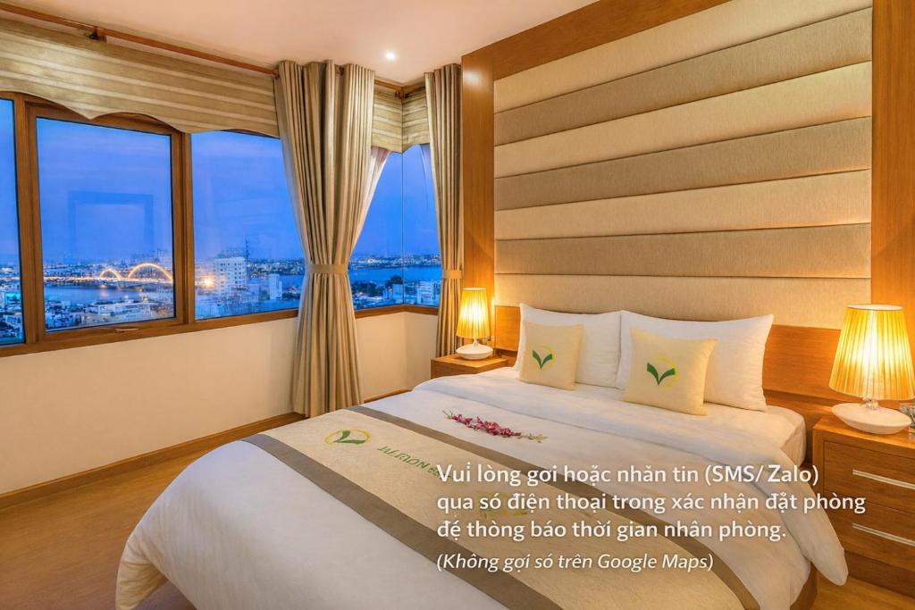 een hotelkamer met een bed met een raam bij MOONLIGHT Hotel & Suites - The Best City View, Dragon Bridge view in Da Nang