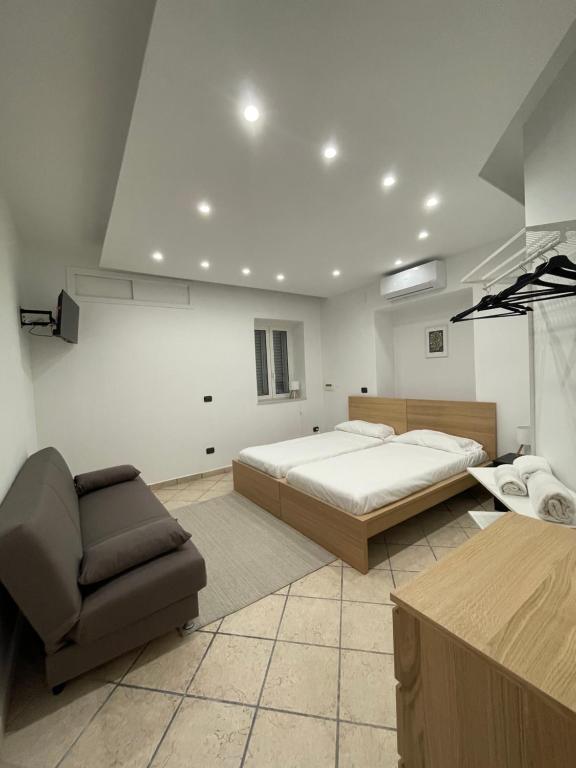 een grote slaapkamer met een bed en een stoel bij Carioca Aparthotel in Capua