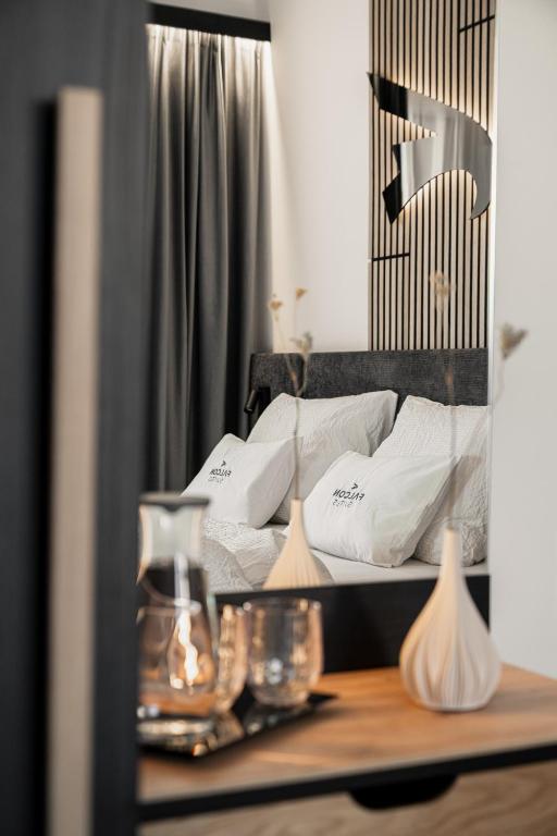 a bedroom with a bed with white pillows on it at Falcon Suites Pure - Summercard included in Kaprun