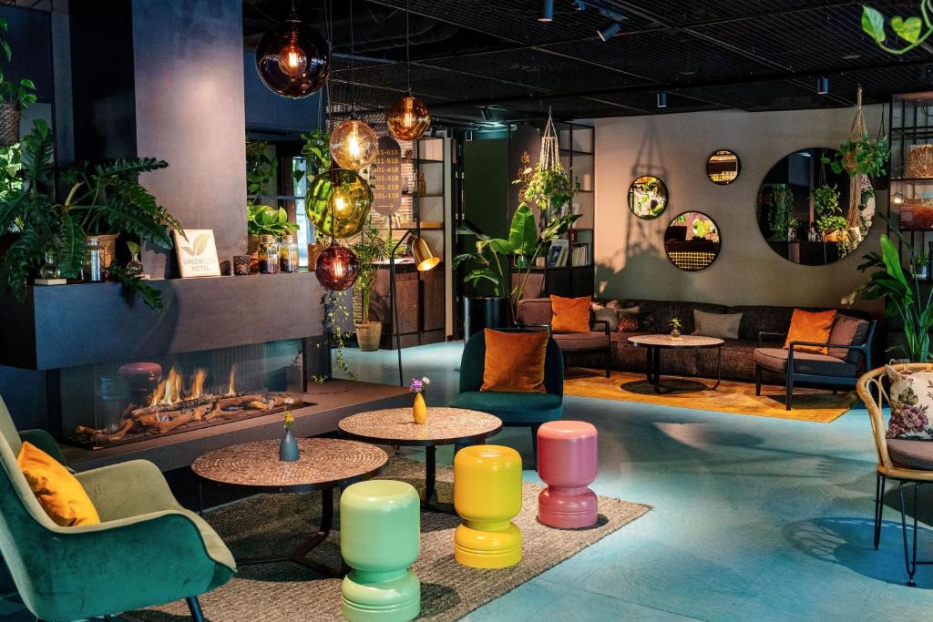 a lobby with tables and chairs and a fireplace at Cocoon München Sendlinger Tor in Munich
