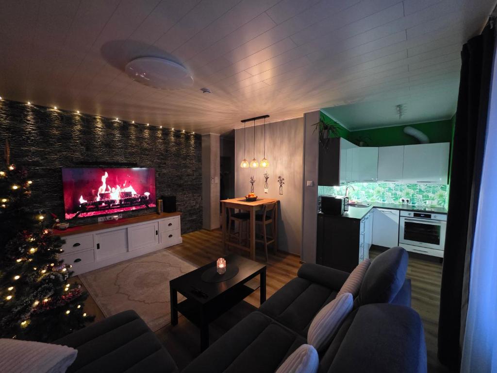 a living room with a couch and a tv and a christmas tree at Green- Guest Apartment- Tapa in Tapa