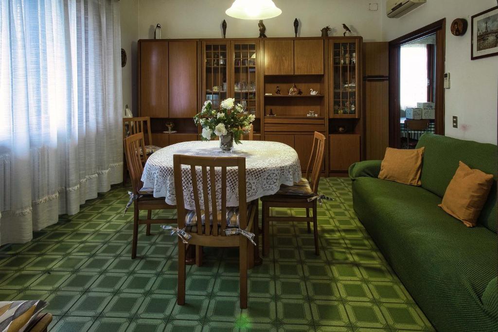 - un salon avec une table et un canapé vert dans l'établissement Casa nella campagna Toscana, à Lazzeretto