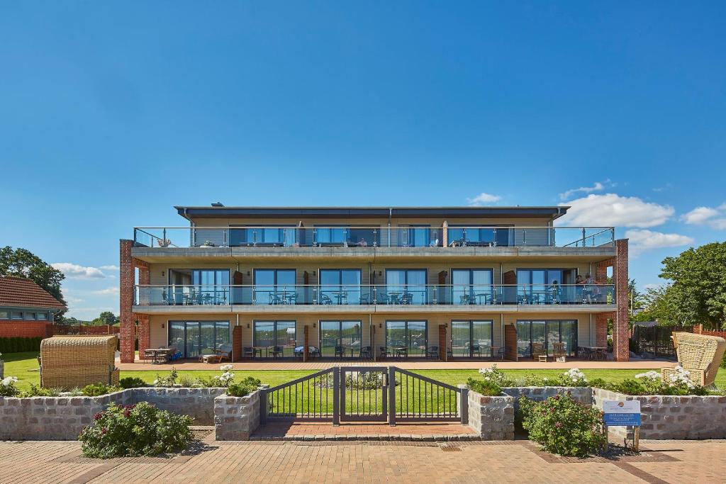 un gran edificio con una valla delante en Ostsee-Strandhaus-Holnis en Glücksburg