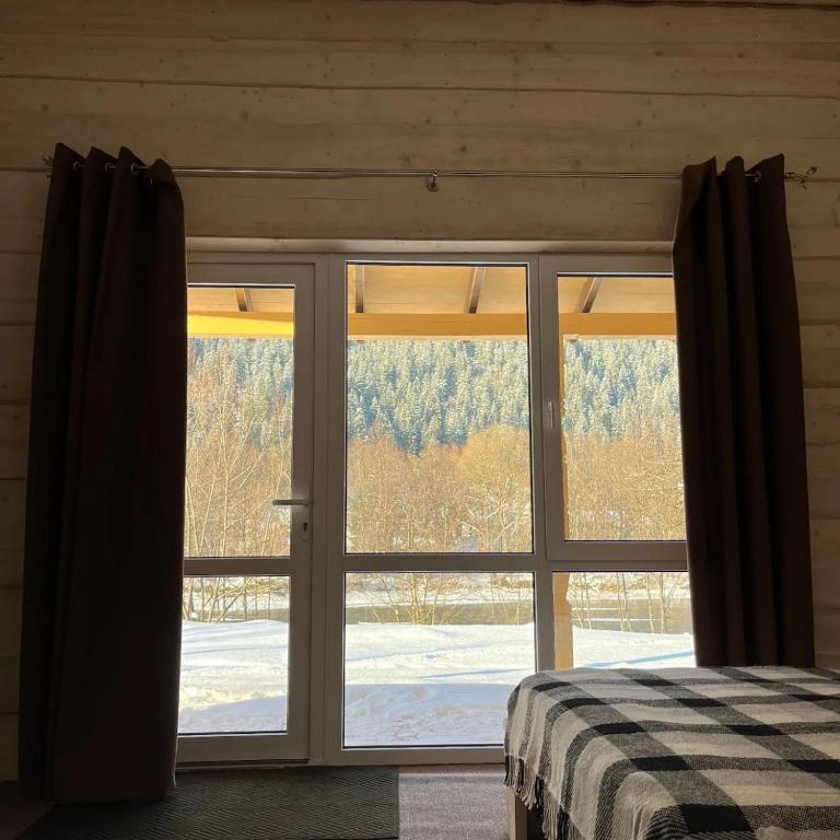 a bedroom with a large sliding glass door at Cozy Rest House in Verkhovyna
