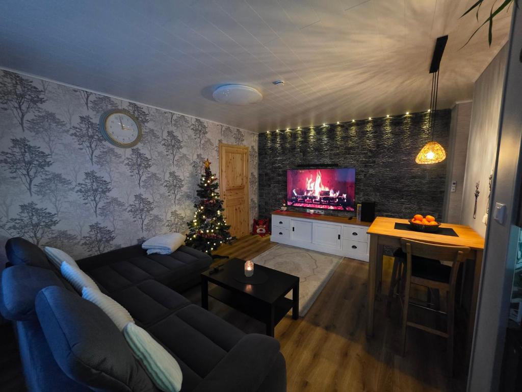 een woonkamer met een bank en een kerstboom bij Green- Guest Apartment- Tapa in Taps