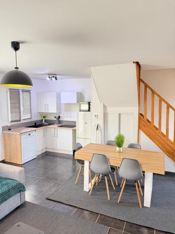 eine Küche und ein Esszimmer mit Tisch und Stühlen in der Unterkunft Maison entiere jacuzzi reception ouverte 7 7j et 24 24h in Ambarès-et-Lagrave