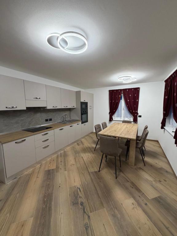 eine Küche und ein Esszimmer mit Tisch und Stühlen in der Unterkunft Chalet La Viola in Alba di Canazei
