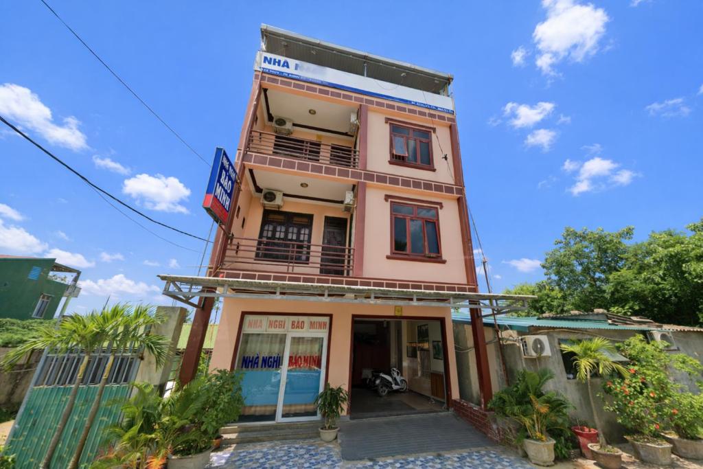 ein großes rosafarbenes Gebäude mit Balkon in der Unterkunft Bảo Minh Motel Đông Hà in Quang Tri