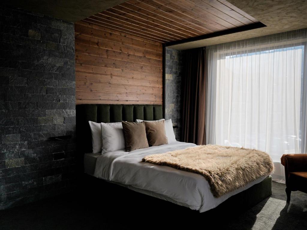 a bedroom with a large bed with a brick wall at Premier Luxury Mountain Resort in Bansko